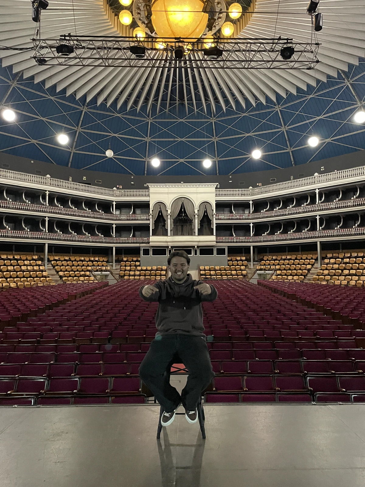 João sentado numa sala de espetáculos