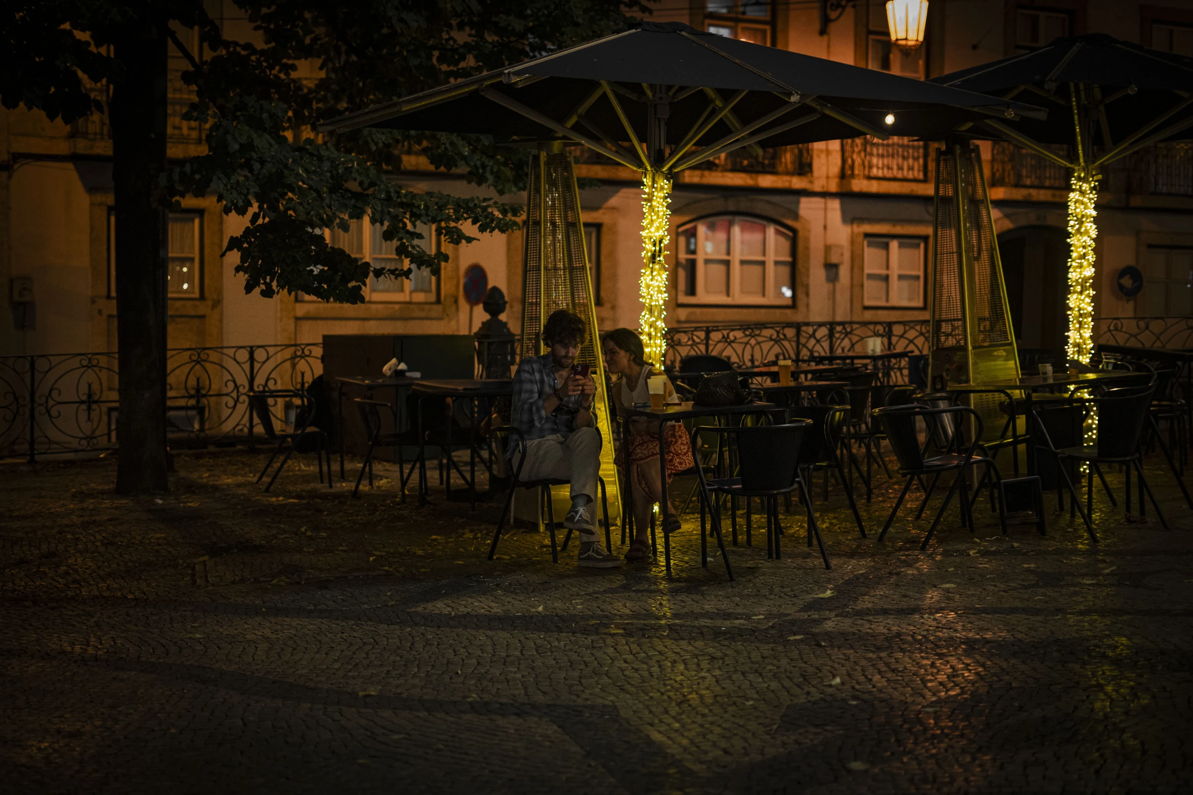 Uma esplanada iluminada à noite.
