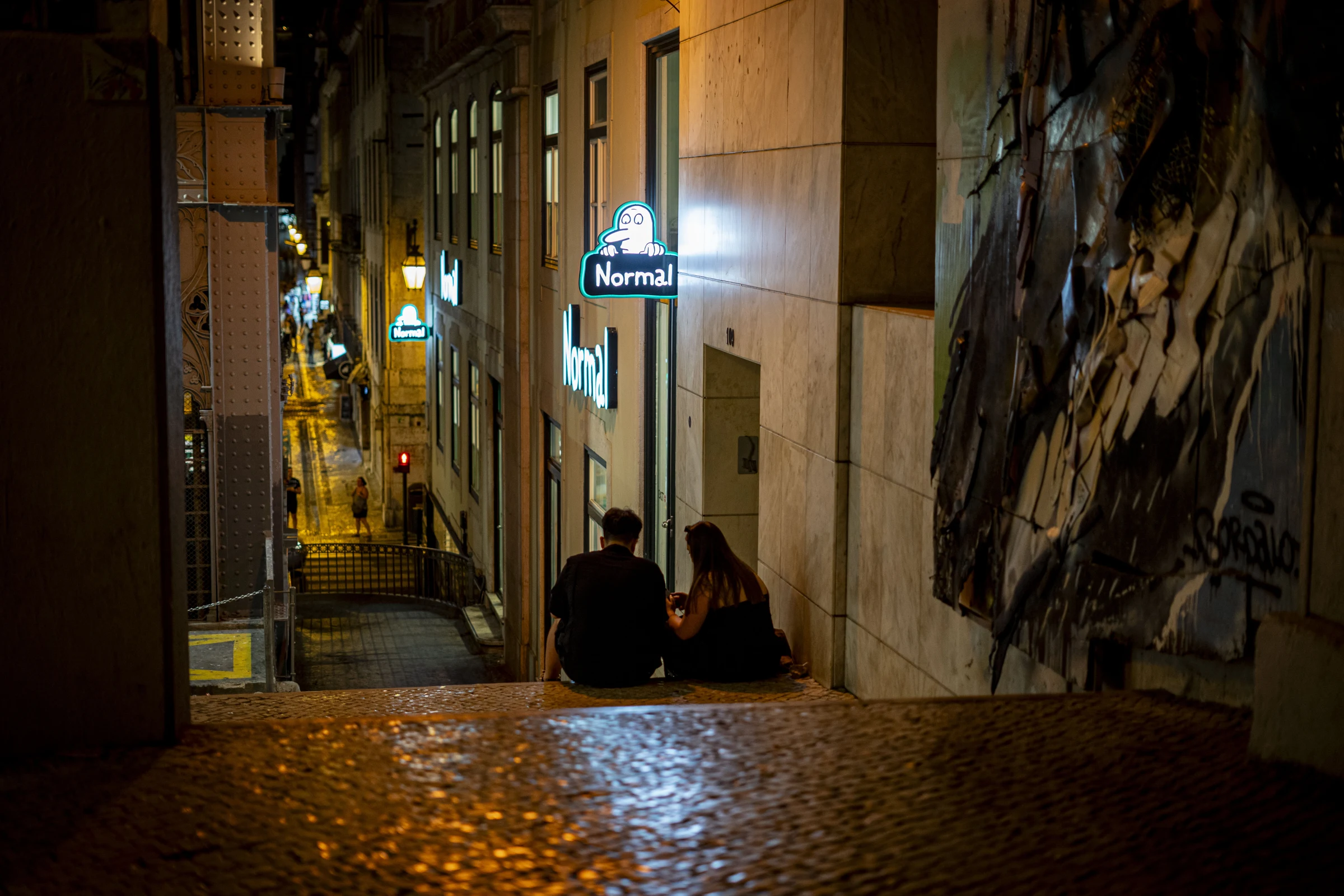 Uma rua de Lisboa iluminada à noite.