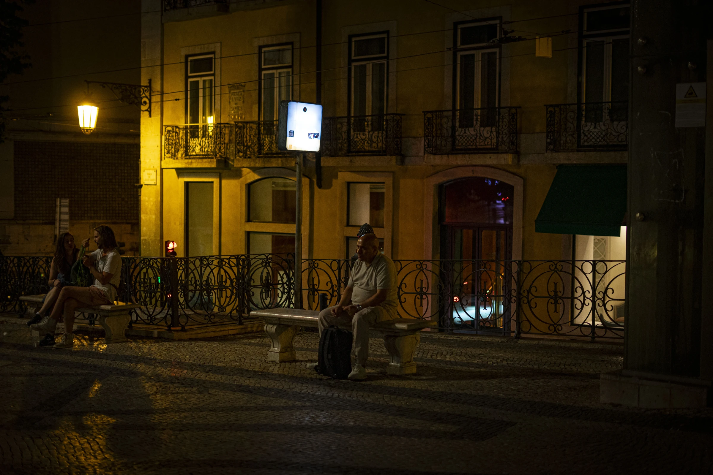 Uma praça com luz quente à noite.